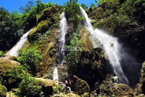 People enjoying the natural beauty of Sri Gethuk Waterfall in Yogyakarta, Indonesia.