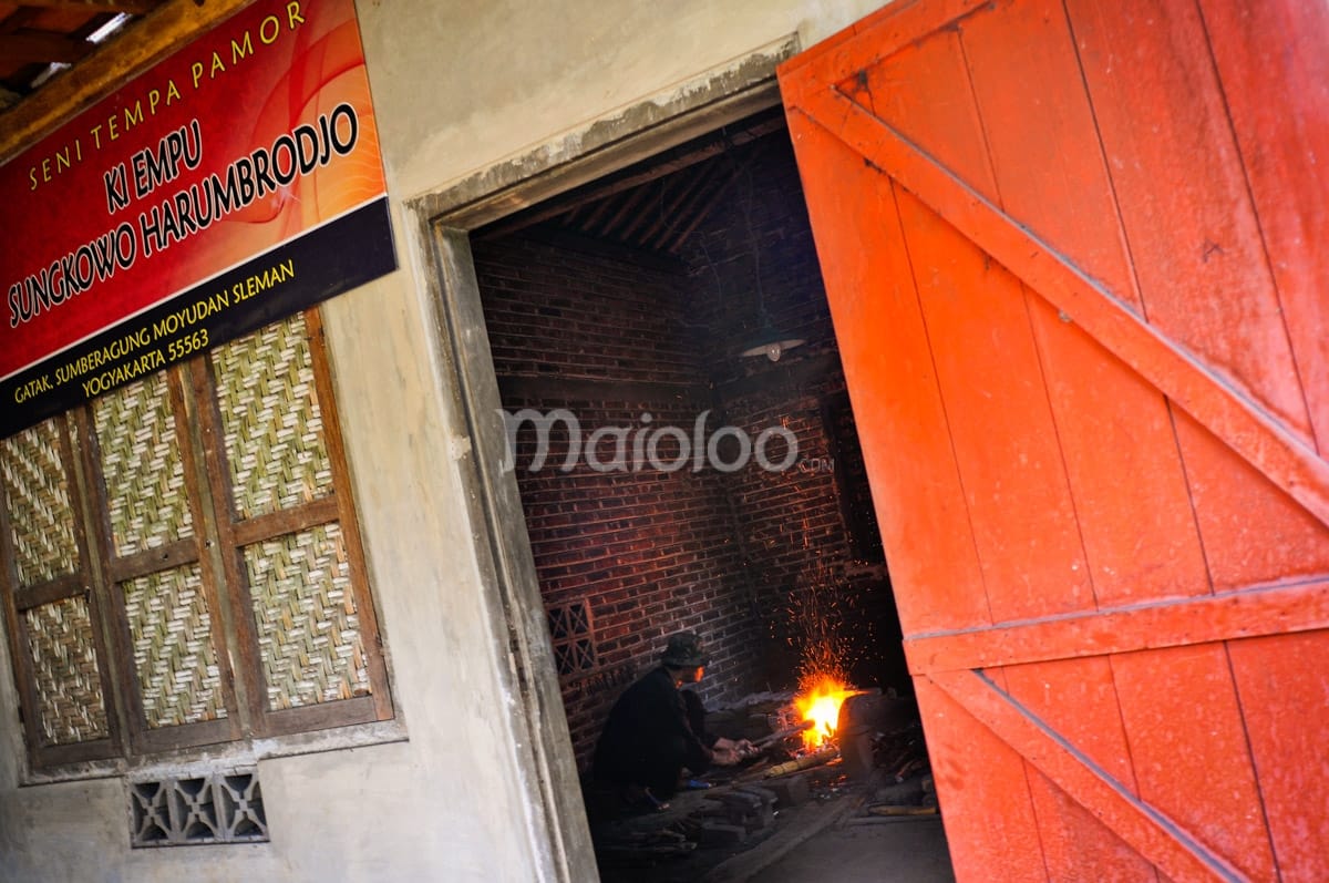 Entrance to Ki Empu Sungkowo Harumbrodjo's keris making workshop with signboard and a glimpse of the forge inside.