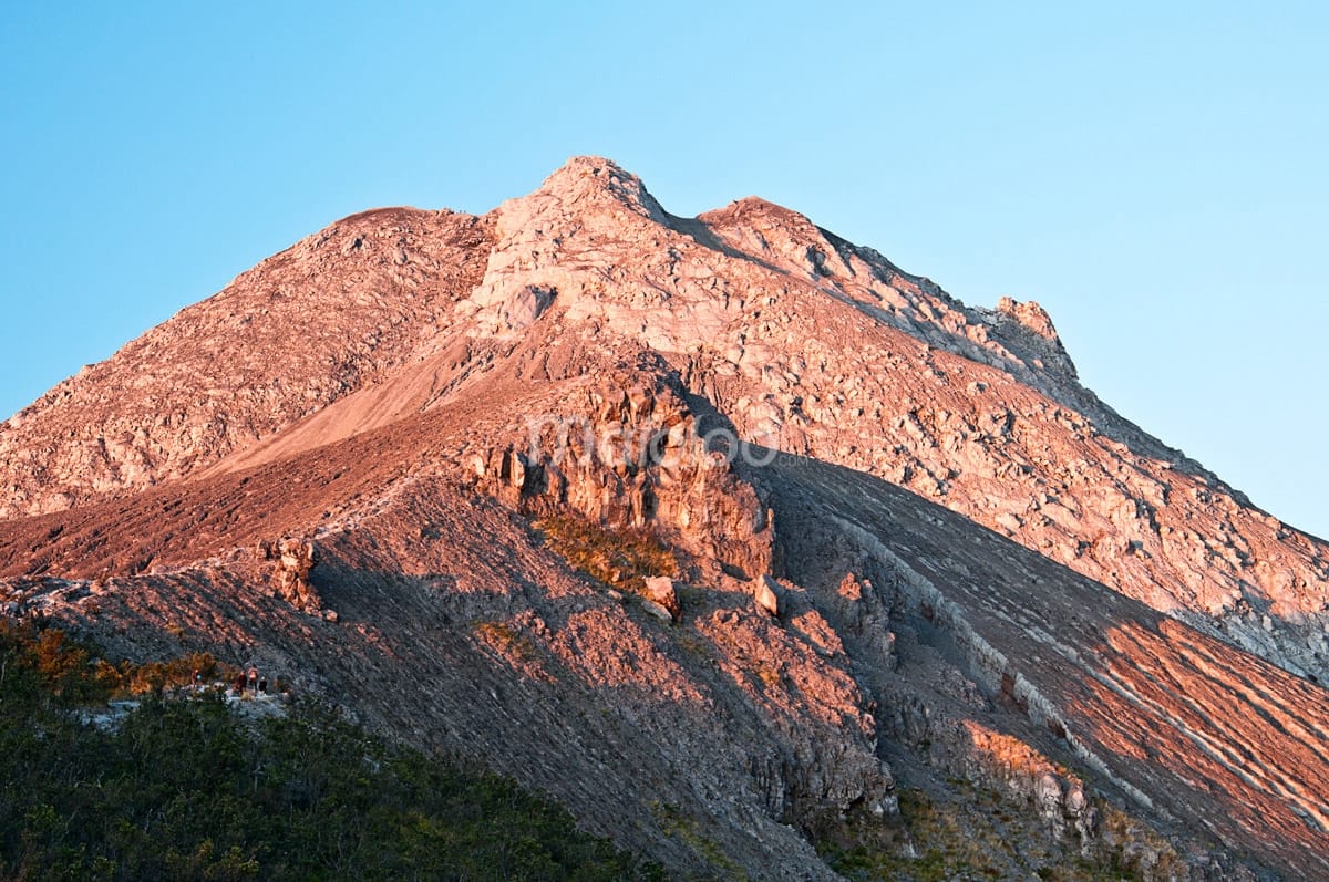 Mount Merapi's rocky summit bathed in warm sunlight, seen from Pasar Bubrah.