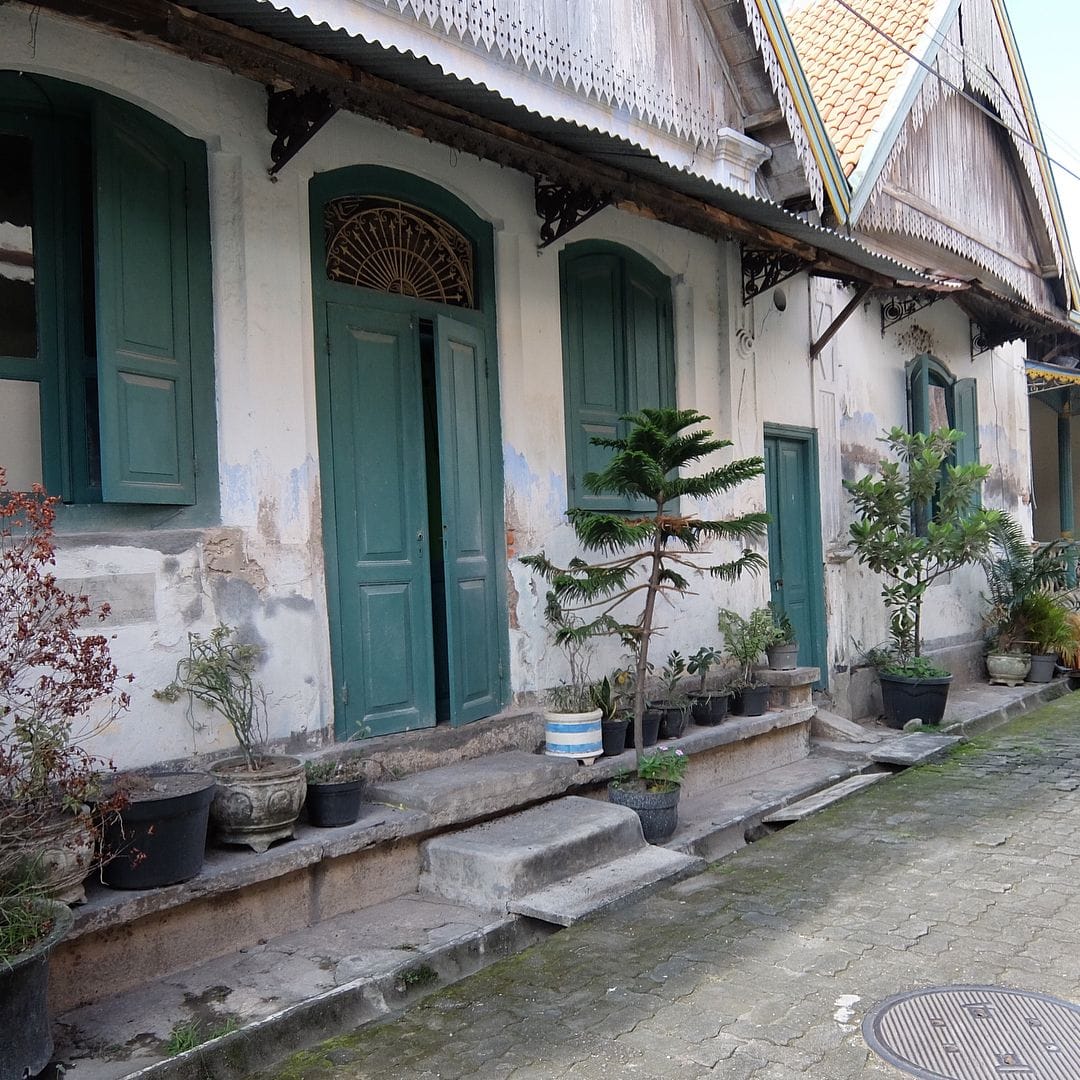 Historic building with green doors and potted plants in Kauman Village.