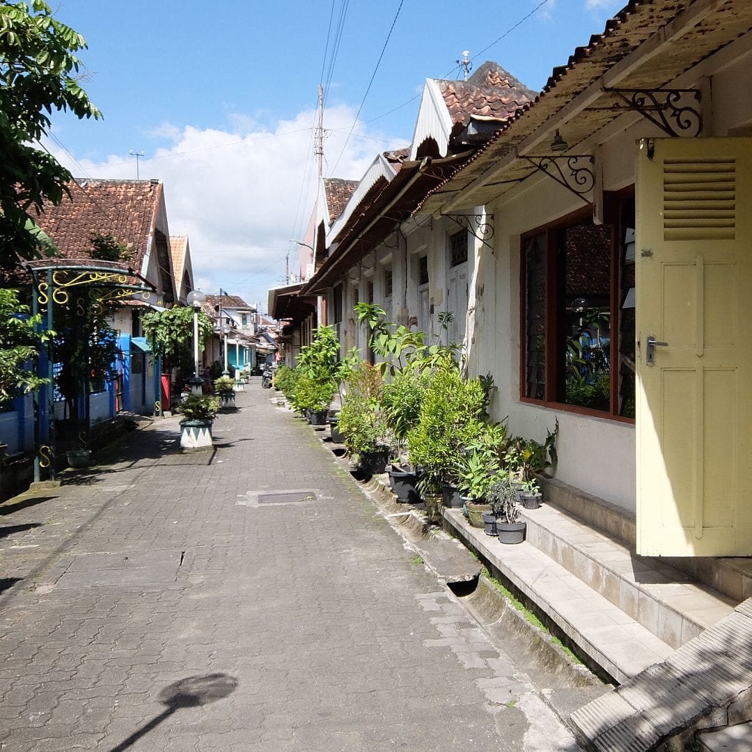 Quiet street with traditional houses and plants in Kauman Village.