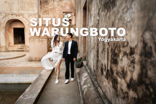 A couple dressed in elegant attire walks through the historic ruins of Warungboto Site in Yogyakarta, a popular pre-wedding photoshoot location.